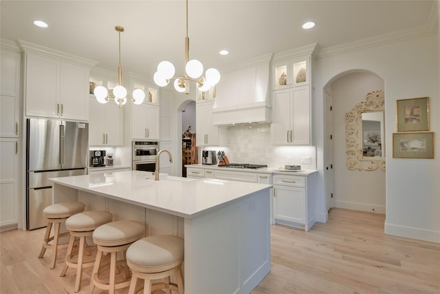 1001 Quarry Ct, Granbury, TX 76048 - kitchen with stainless steel appliances, arched walkways, custom exhaust hood, crown molding, and backsplash