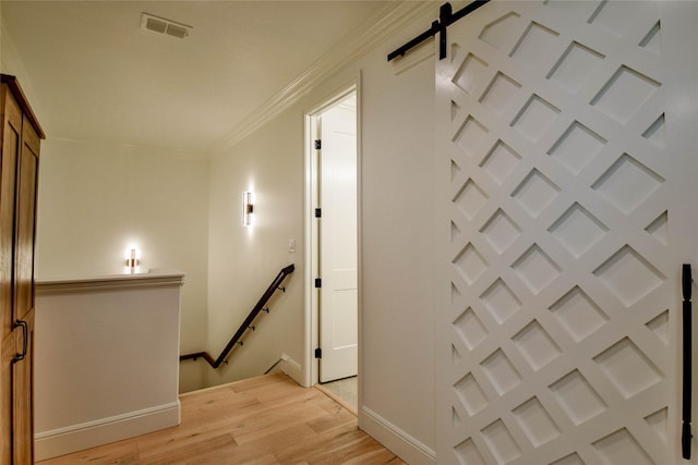 1001 Quarry Ct, Granbury, TX 76048 - hall featuring an upstairs landing, light wood-style flooring, a barn door, and ornamental molding