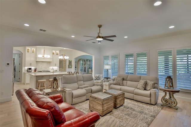 1001 Quarry Ct, Granbury, TX 76048 - living room with arched walkways, a ceiling fan, a chandelier, ornamental molding, and recessed lighting