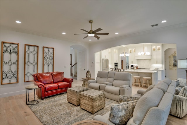 1001 Quarry Ct, Granbury, TX 76048 - living area featuring arched walkways, a chandelier, ceiling fan, light wood-style floors, and recessed lighting