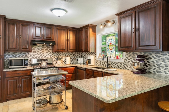 845 Griffith Ave, Terrell, TX 75160 - kitchen featuring under cabinet range hood, stainless steel appliances, decorative backsplash, and light stone counters