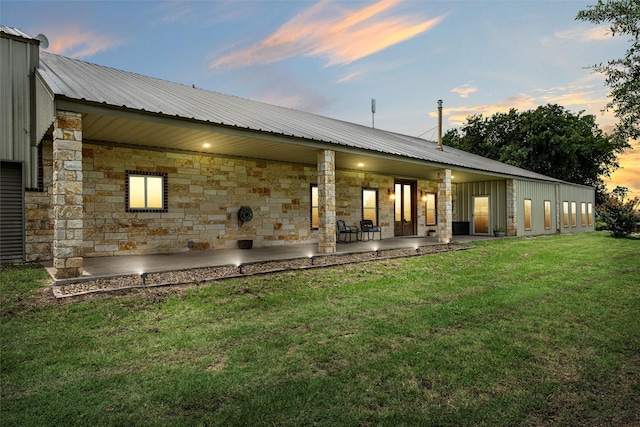 139 County Road 376, Lott, TX 76656 - back of property at dusk with a patio area, a metal roof, a yard, and stone siding