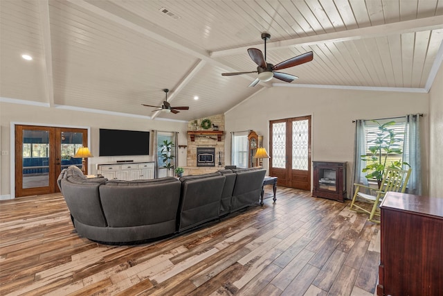 139 County Road 376, Lott, TX 76656 - living room with a stone fireplace, french doors, wood finished floors, a ceiling fan, and plenty of natural light
