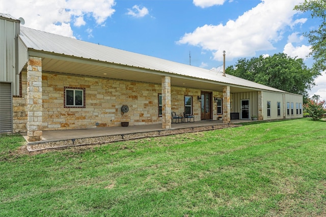 139 County Road 376, Lott, TX 76656 - back of house featuring a lawn, a metal roof, a patio area, and stone siding