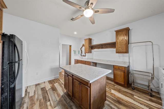 139 County Road 376, Lott, TX 76656 - kitchen featuring freestanding refrigerator, ceiling fan, brown cabinetry, wood finished floors, and recessed lighting