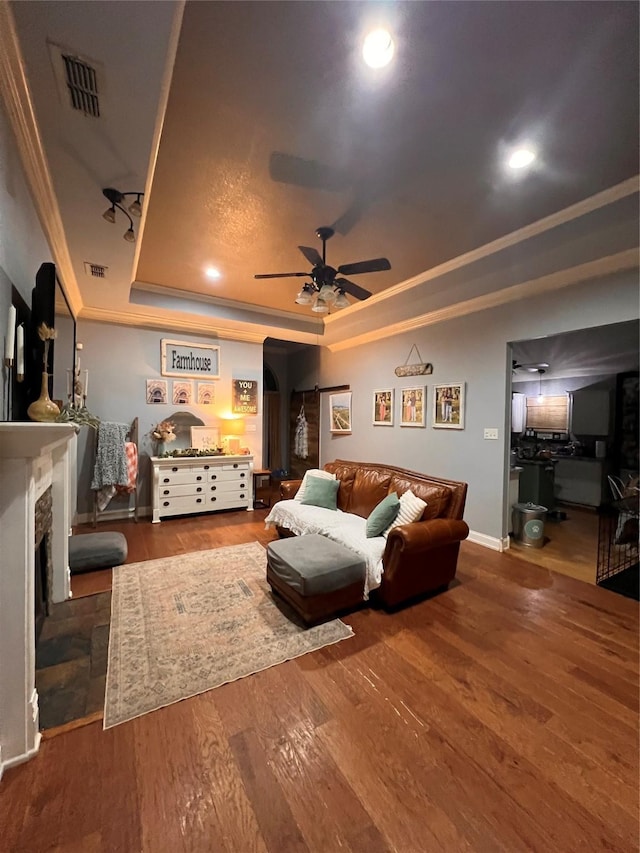 1507 Bridge Water Ln, Mansfield, TX 76063 - living room featuring a raised ceiling, a ceiling fan, ornamental molding, arched walkways, and wood finished floors