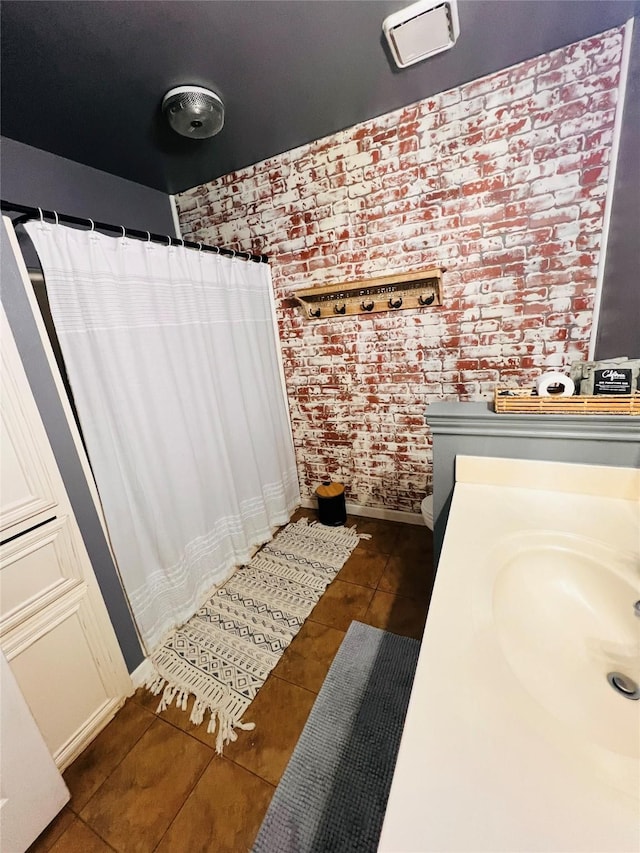1507 Bridge Water Ln, Mansfield, TX 76063 - bathroom featuring tile patterned flooring, brick wall, vanity, and curtained shower