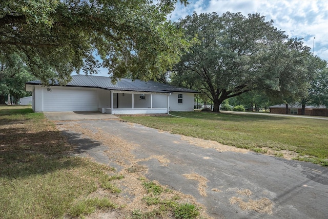 1007 Monte Carlo Dr, Grand Saline, TX 75140 - ranch-style house with driveway, a front yard, a metal roof, and a carport