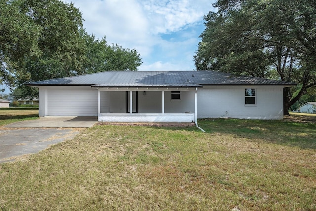 1007 Monte Carlo Dr, Grand Saline, TX 75140 - rear view of house featuring a metal roof, a yard, and driveway