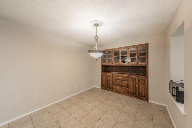 5105 French Wood Dr, Arlington, TX 76016 - unfurnished dining area featuring light tile patterned floors and a textured ceiling