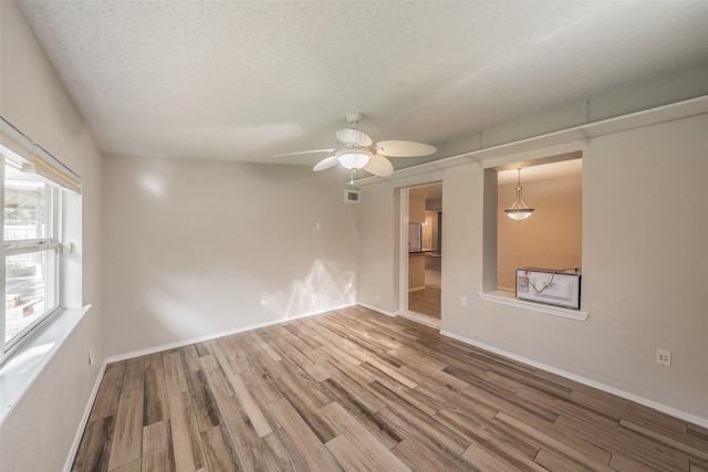 5105 French Wood Dr, Arlington, TX 76016 - empty room with wood finished floors, a ceiling fan, and a textured ceiling