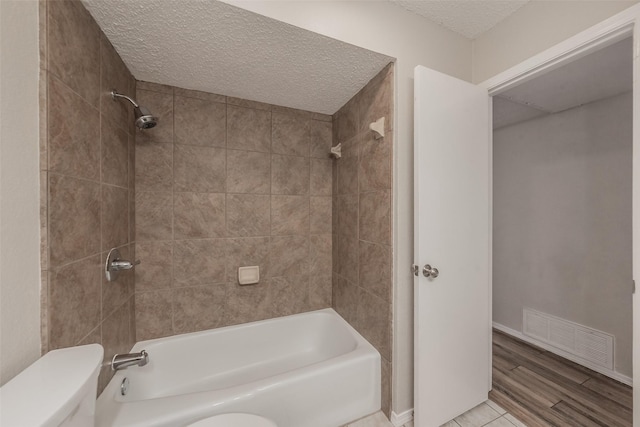 5105 French Wood Dr, Arlington, TX 76016 - bathroom featuring a textured ceiling, bathtub / shower combination, and wood finished floors