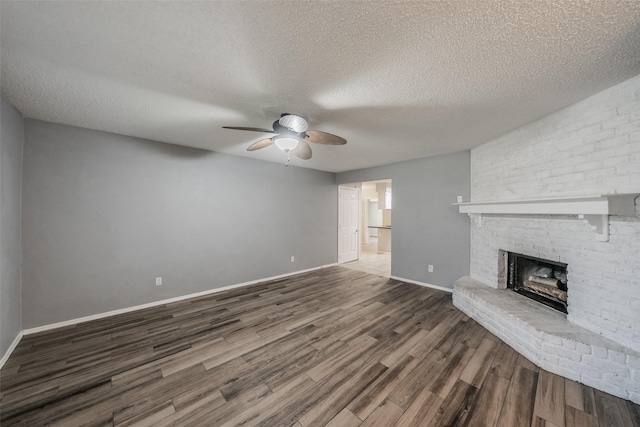 5105 French Wood Dr, Arlington, TX 76016 - unfurnished living room featuring a ceiling fan, a brick fireplace, wood finished floors, and a textured ceiling