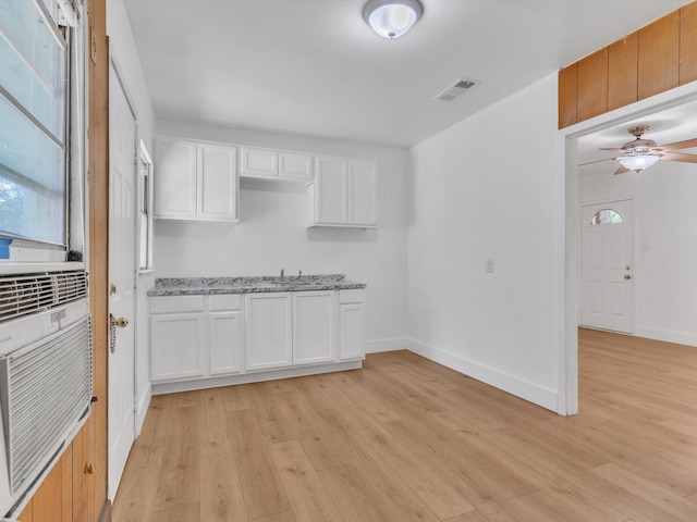 422 11th St, Grand Prairie, TX 75051 - kitchen featuring light wood-type flooring, light stone countertops, white cabinets, a ceiling fan, and plenty of natural light