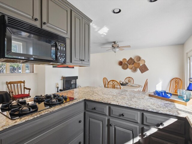 3207 Lynnwood Dr, Arlington, TX 76013 - kitchen with black appliances, gray cabinets, ceiling fan, and light stone countertops