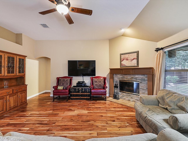 1597 Sweetbriar Dr, Allen, TX 75002 - living area featuring a ceiling fan, wood finished floors, arched walkways, lofted ceiling, and a stone fireplace
