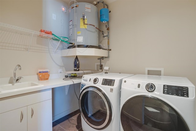 2600 W 7th St Unit 2452, Fort Worth, TX 76107 - laundry area with washer and clothes dryer, water heater, cabinet space, and dark tile patterned flooring