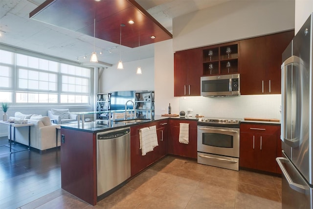 2600 W 7th St Unit 2452, Fort Worth, TX 76107 - kitchen with appliances with stainless steel finishes, dark countertops, backsplash, a peninsula, and open floor plan