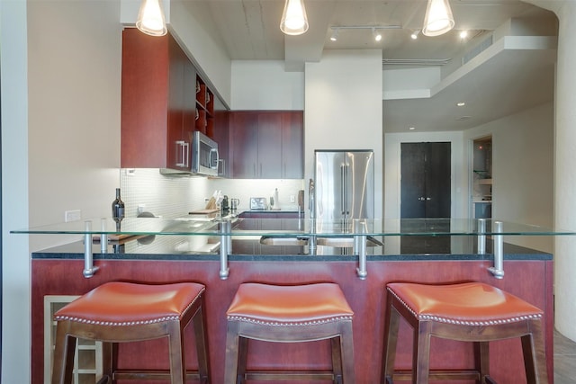 2600 W 7th St Unit 2452, Fort Worth, TX 76107 - kitchen featuring stainless steel appliances, backsplash, a peninsula, and dark stone counters