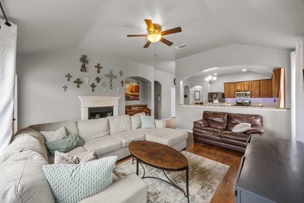 2732 Cowboy Trl, Little Elm, TX 75068 - living room with lofted ceiling, arched walkways, wood finished floors, ceiling fan, and a fireplace