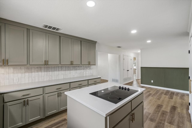 110 Vz County Road 1128, Fruitvale, TX 75127 - kitchen featuring gray cabinets, black electric cooktop, light countertops, wood finished floors, and a wainscoted wall