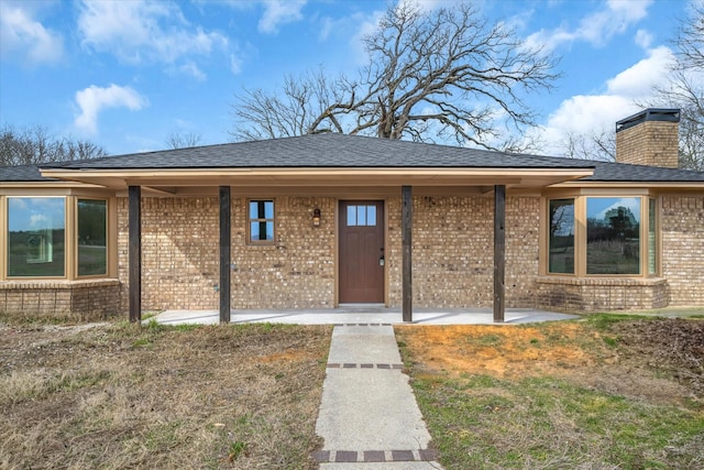 110 Vz County Road 1128, Fruitvale, TX 75127 - view of exterior entry with brick siding, a chimney, roof with shingles, and a patio