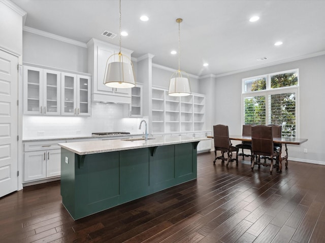 324 Nursery Ln, Fort Worth, TX 76114 - kitchen with crown molding, white cabinetry, light stone countertops, a kitchen island with sink, and glass insert cabinets