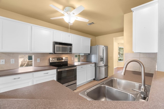 108 Bear Trl, Waxahachie, TX 75165 - kitchen featuring stainless steel appliances, tasteful backsplash, white cabinetry, and a ceiling fan
