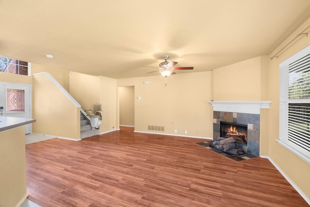 108 Bear Trl, Waxahachie, TX 75165 - unfurnished living room with ceiling fan, a fireplace, wood finished floors, and stairway