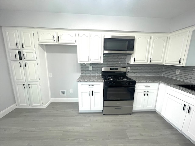 5146 Fm 879, Palmer, TX 75152 - kitchen featuring appliances with stainless steel finishes, backsplash, white cabinets, and light wood finished floors