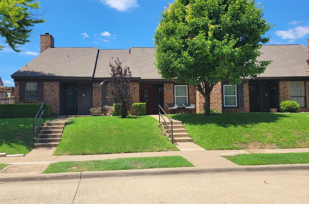 5021 Buttonwood Ln, Garland, TX 75043 - view of front of property with a front lawn, brick siding, and a chimney