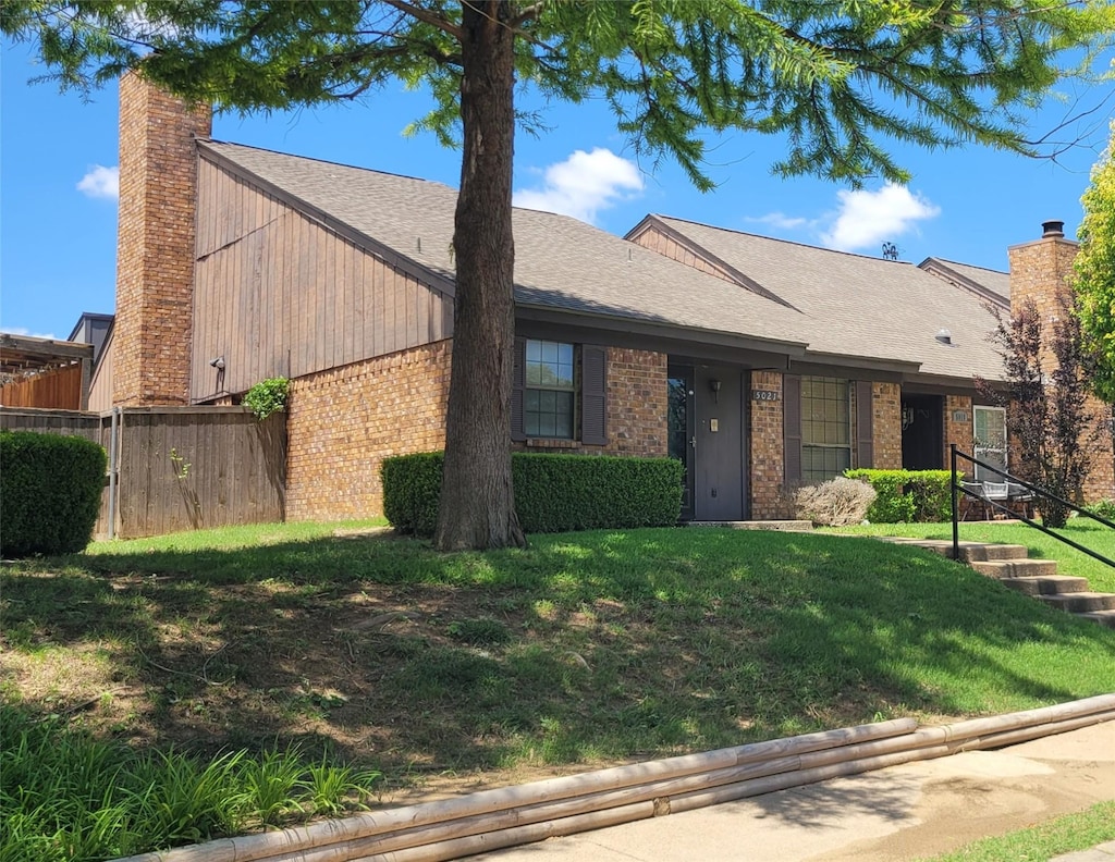 5021 Buttonwood Ln, Garland, TX 75043 - view of front facade with a chimney, brick siding, and a shingled roof