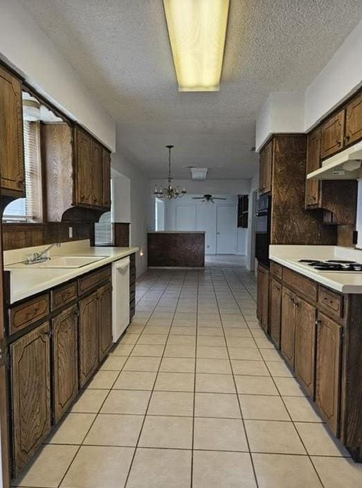 1601 Meadow Ln, Terrace, Fort Worth, TX 76112 - kitchen featuring white appliances, under cabinet range hood, a textured ceiling, a chandelier, and light countertops