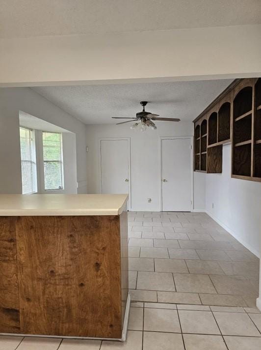1601 Meadow Ln, Terrace, Fort Worth, TX 76112 - kitchen with a ceiling fan, light tile patterned floors, light countertops, and a peninsula