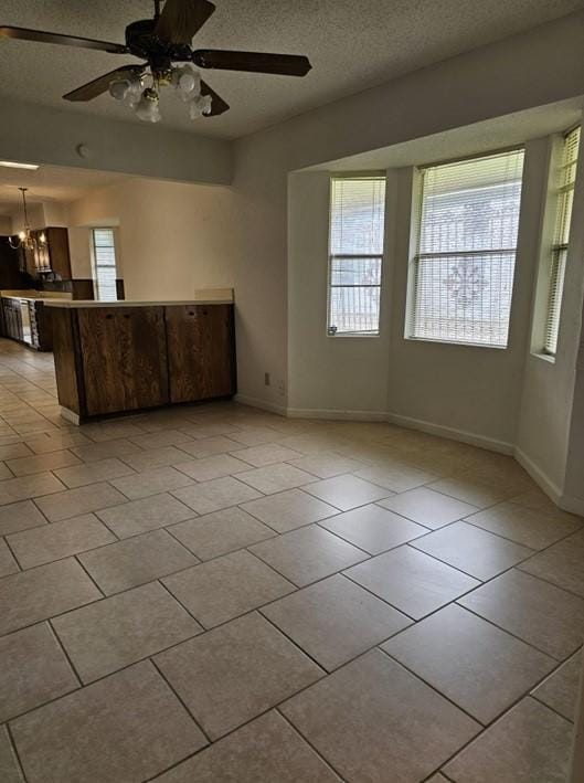 1601 Meadow Ln, Terrace, Fort Worth, TX 76112 - unfurnished living room with light tile patterned floors, ceiling fan, a chandelier, and a textured ceiling