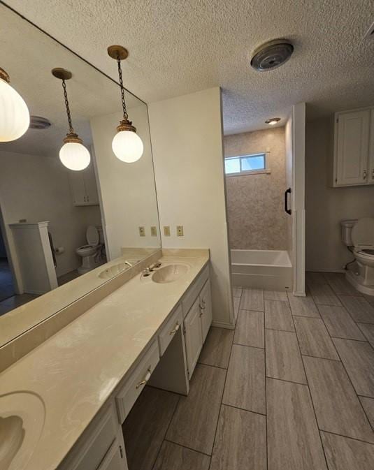 1601 Meadow Ln, Terrace, Fort Worth, TX 76112 - full bathroom with double vanity, wood tiled floors, shower / bath combination, and a textured ceiling