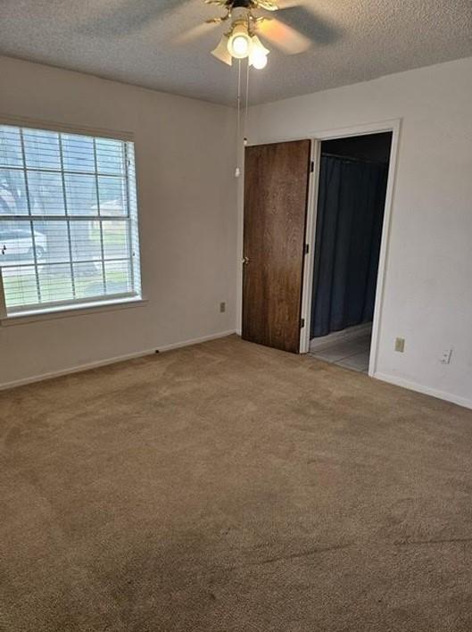 1601 Meadow Ln, Terrace, Fort Worth, TX 76112 - unfurnished bedroom featuring light carpet, a textured ceiling, and ceiling fan