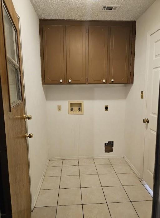 1601 Meadow Ln, Terrace, Fort Worth, TX 76112 - washroom with electric dryer hookup, washer hookup, cabinet space, a textured ceiling, and light tile patterned floors