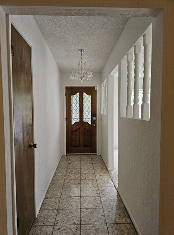 1601 Meadow Ln, Terrace, Fort Worth, TX 76112 - entryway featuring a chandelier and baseboards