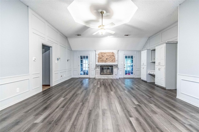 1237 Linkwood Ln, Lancaster, TX 75146 - unfurnished living room featuring a decorative wall, dark wood-style floors, a ceiling fan, lofted ceiling, and a brick fireplace