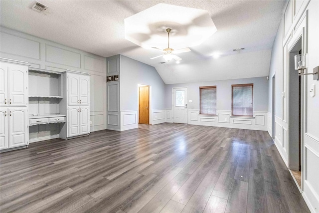 1237 Linkwood Ln, Lancaster, TX 75146 - unfurnished bedroom featuring a decorative wall, dark wood finished floors, a textured ceiling, vaulted ceiling, and ceiling fan