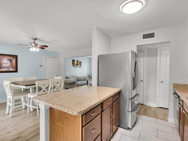 6708 Wagonet Rd, Forest Hill, TX 76140 - kitchen featuring appliances with stainless steel finishes, light countertops, ceiling fan, and brown cabinets