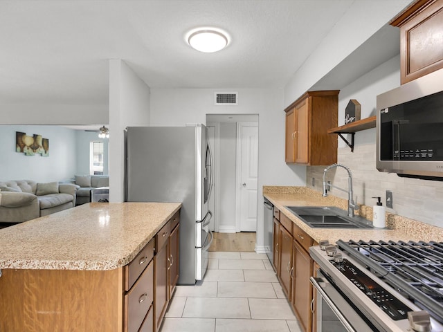 6708 Wagonet Rd, Forest Hill, TX 76140 - kitchen featuring appliances with stainless steel finishes, open shelves, tasteful backsplash, brown cabinetry, and open floor plan