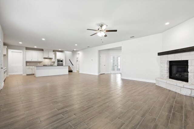 260 Clairmont Dr, Ponder, TX 76259 - unfurnished living room featuring a ceiling fan, recessed lighting, wood finished floors, and a stone fireplace