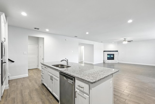 260 Clairmont Dr, Ponder, TX 76259 - kitchen with dishwasher, a ceiling fan, a stone fireplace, white cabinetry, and light stone counters