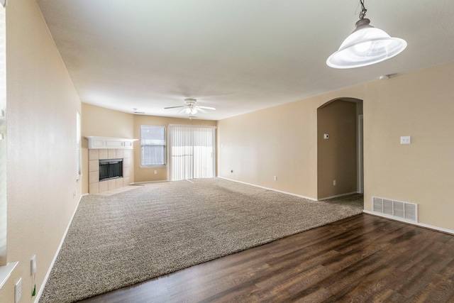 13264 Harvest Ridge Rd, Fort Worth, TX 76244 - unfurnished living room featuring arched walkways, a ceiling fan, wood finished floors, and a fireplace