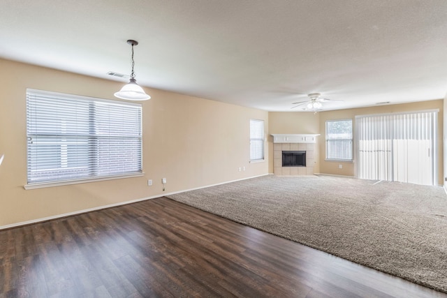13264 Harvest Ridge Rd, Fort Worth, TX 76244 - unfurnished living room featuring ceiling fan, a tiled fireplace, and wood finished floors