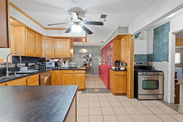 2200 SE 26th Ave, Mineral Wells, TX 76067 - kitchen featuring appliances with stainless steel finishes, dark countertops, a ceiling fan, light tile patterned floors, and tasteful backsplash