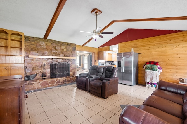 2200 SE 26th Ave, Mineral Wells, TX 76067 - living room featuring wood walls, a ceiling fan, lofted ceiling, light tile patterned floors, and a stone fireplace