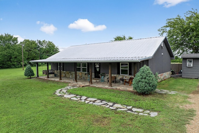 1008 County Road 4759, Sulphur Springs, TX 75482 - back of house with a patio, a lawn, a metal roof, and stone siding